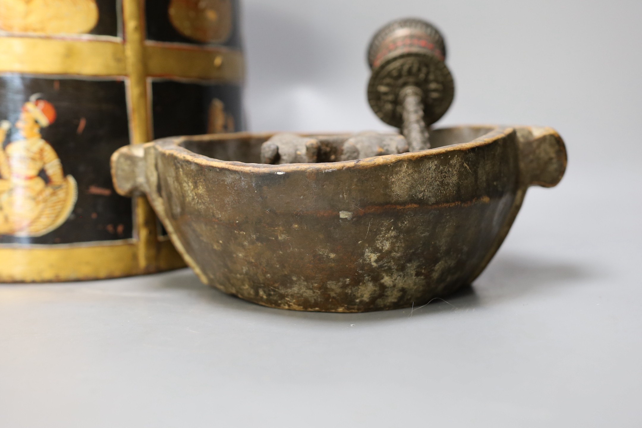 An African carved wood bowl, a Tibetan prayer wheel and a Persian waste basket